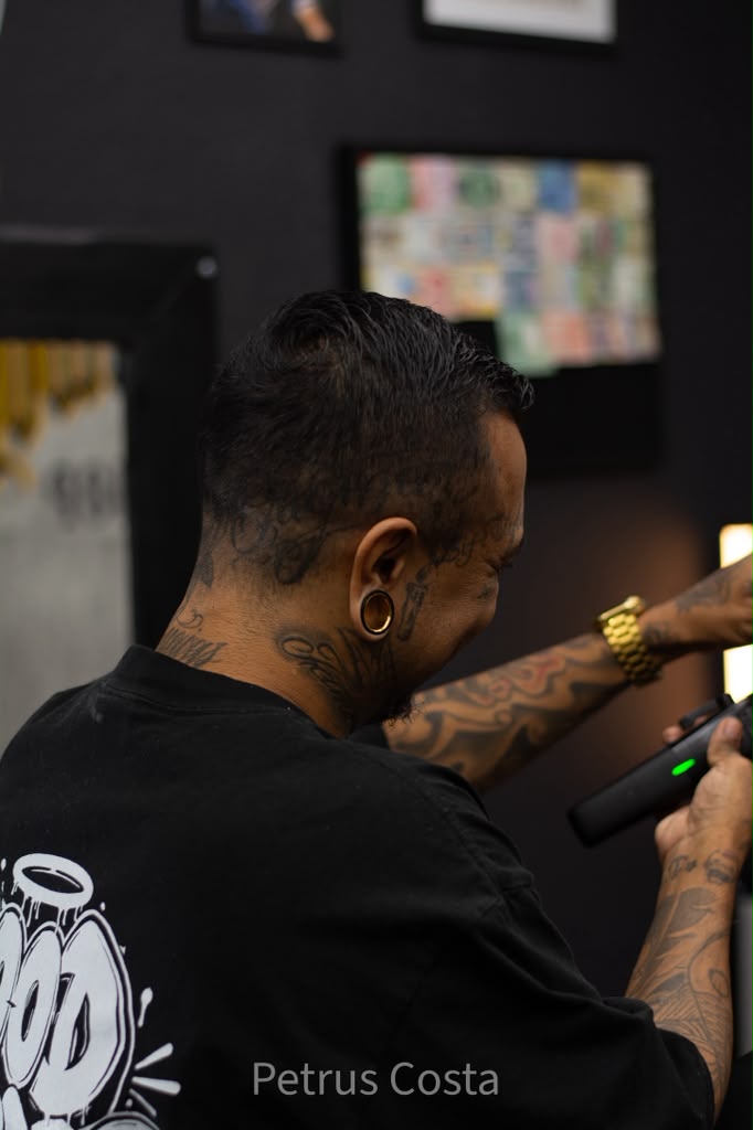 Barber holding a clipper showing precision tools at Brotherhood Barbershop in Deerfield Beach, FL