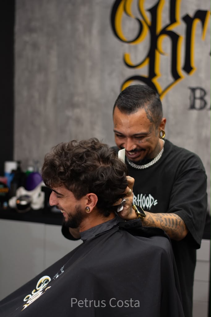 Barber styling a curly haircut at Brotherhood Barbershop in Deerfield Beach, FL