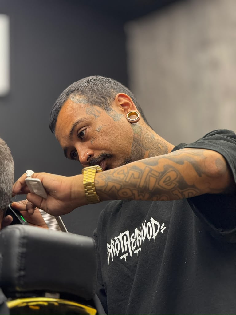 Barber doing precision fade work with comb and clipper at Brotherhood Barbershop in Deerfield Beach, FL